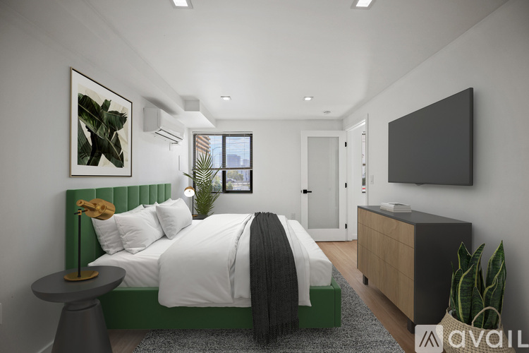 A modern bedroom with a large bed and a green headboard.