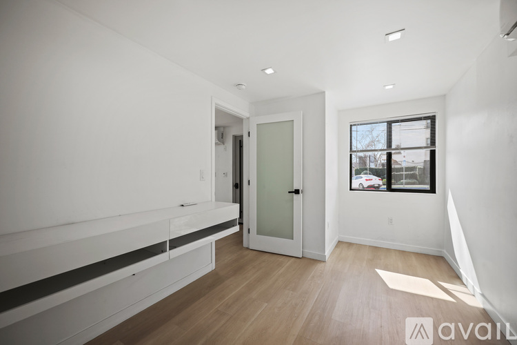 A spacious, empty room with a window overlooking a street.