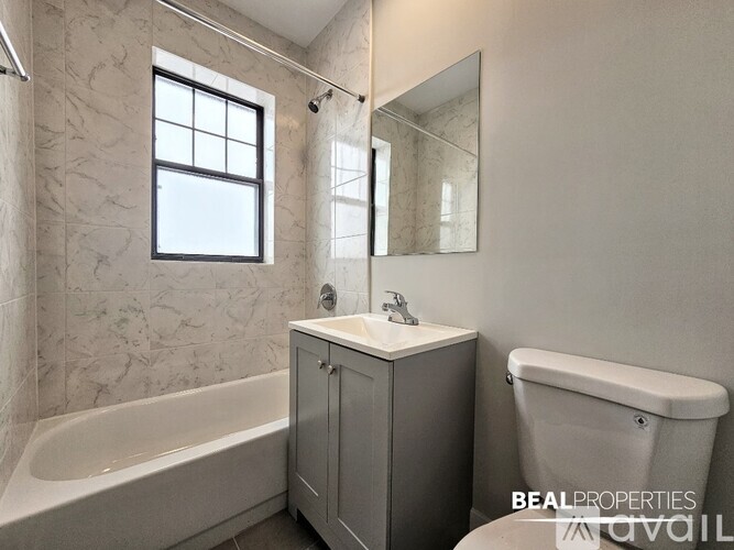 A bathroom with a tub, sink, and mirror.