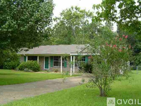 A house with a green door and a tree in front of it.