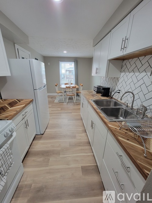 A kitchen with white cabinets and wooden countertops.