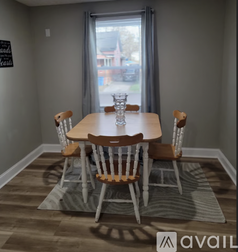 A dining room with a wooden table and chairs.