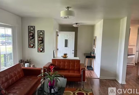 A living room with a red couch and a rug.