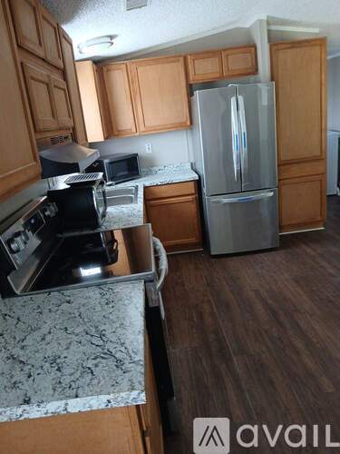 A kitchen with wooden cabinets and a granite counter top.