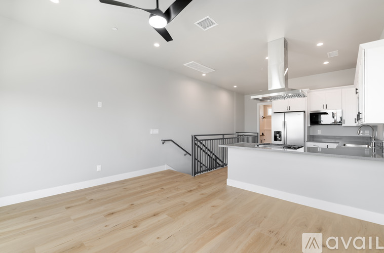 A spacious kitchen area with a fan and a staircase.