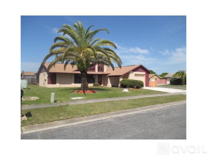 A palm tree stands in front of a house.