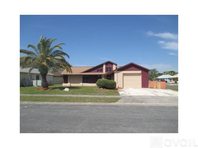 A house with a garage and a palm tree in front.