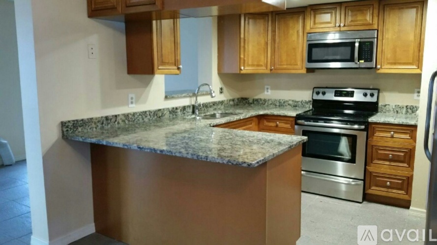 A kitchen with wooden cabinets and granite countertops.