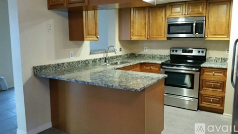A kitchen with wooden cabinets and granite countertops.