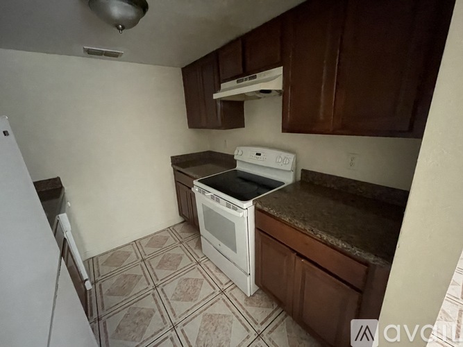 A kitchen with a white oven and brown cabinets.