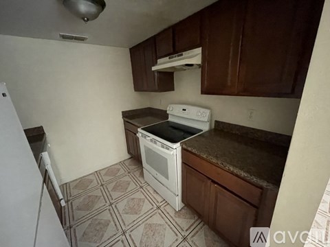 A kitchen with a white oven and brown cabinets.