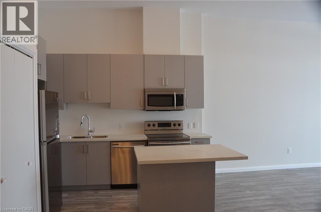 A kitchen with a refrigerator, sink, and stove.