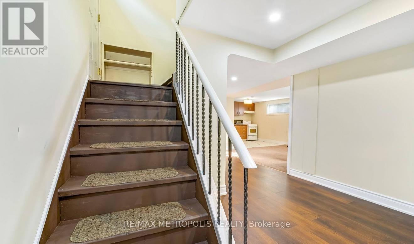 A staircase with a metal railing and wooden steps leading to a landing.