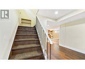 A staircase with a metal railing and wooden steps leading to a landing.