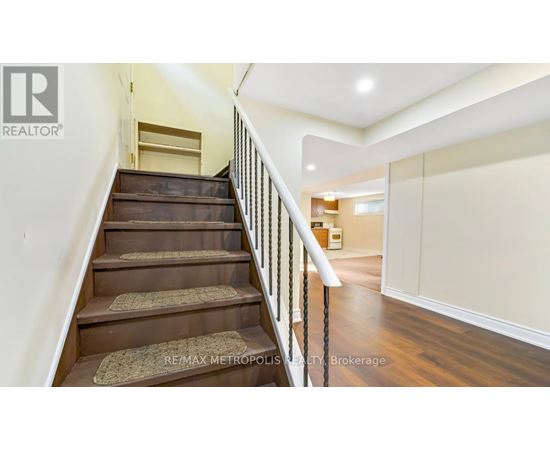 A staircase with a metal railing and wooden steps leading to a landing.