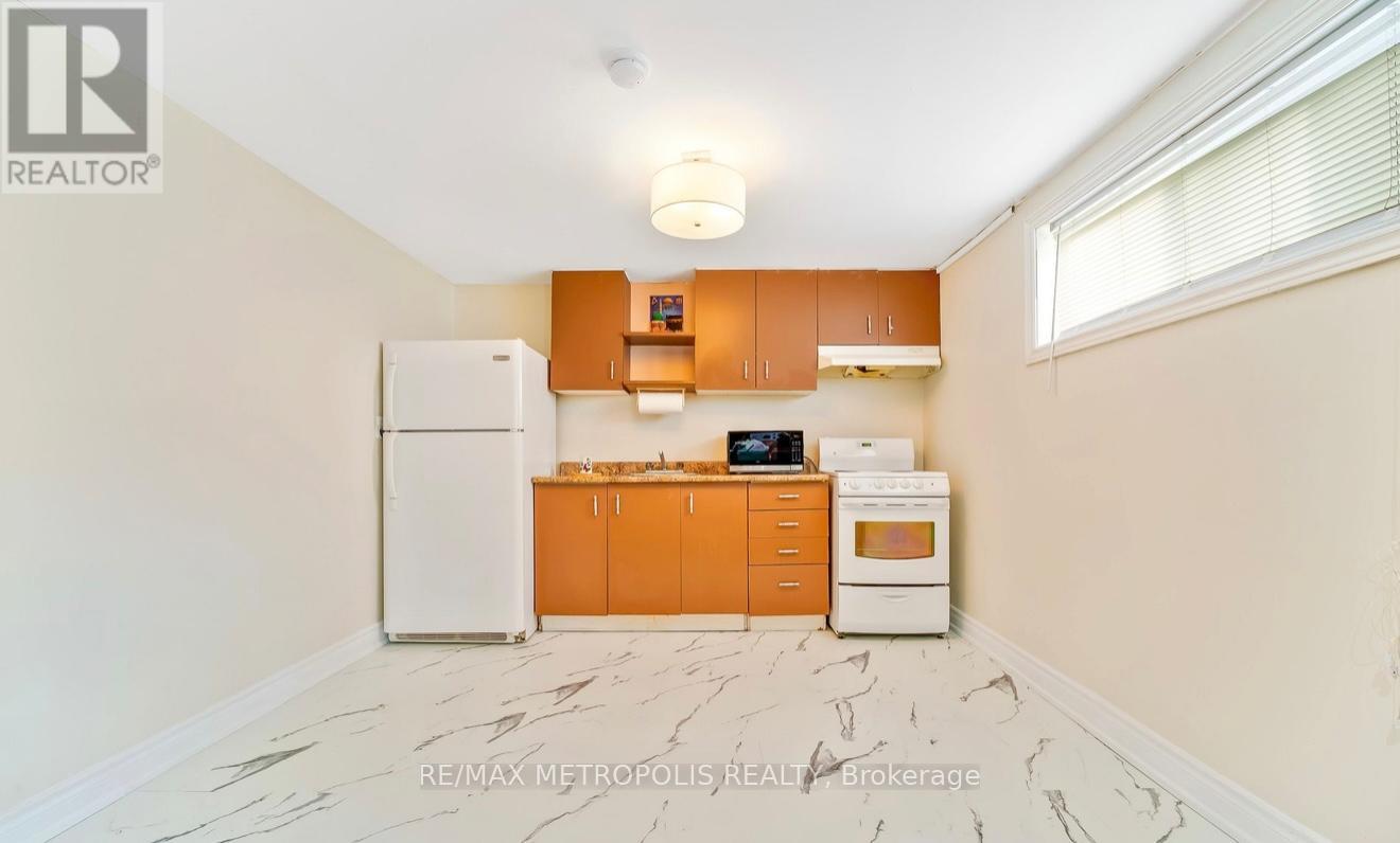 A kitchen with a white fridge, orange cabinets, and a marble floor.