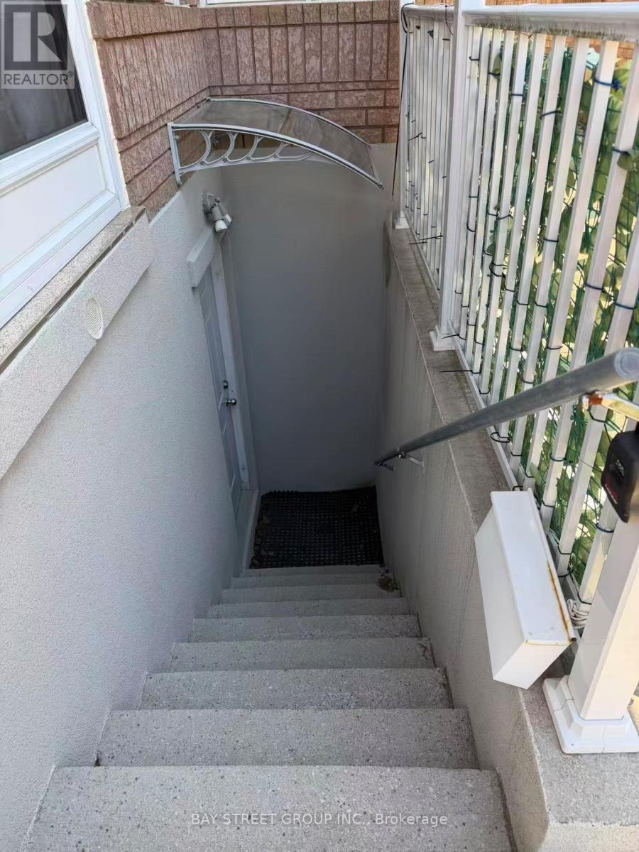 A stairway leading down to a basement with a white railing.