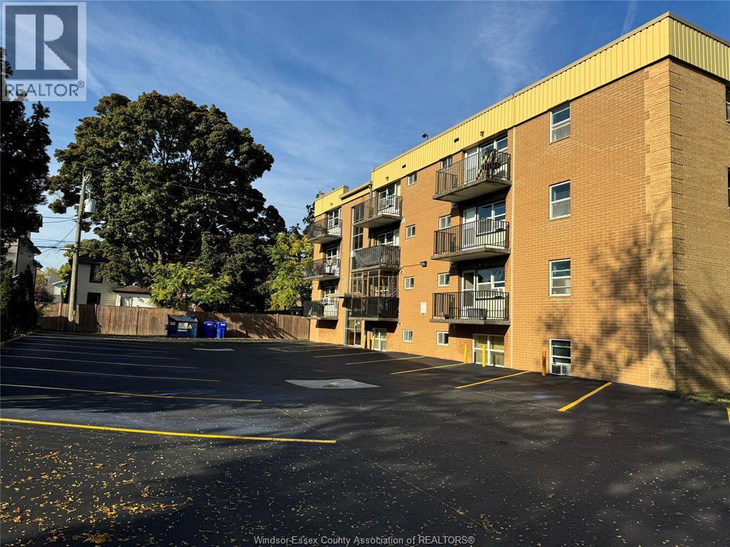 A parking lot in front of a brick apartment building.