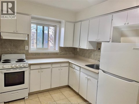 A kitchen with white appliances and cabinets.