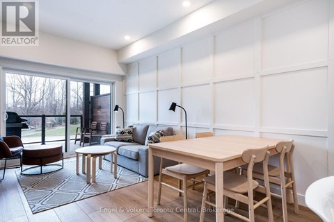 A well-lit, modern living room with a dining table and chairs.
