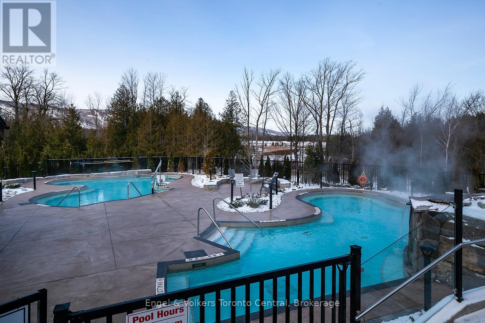 A brokerage sign is displayed in front of a pool.