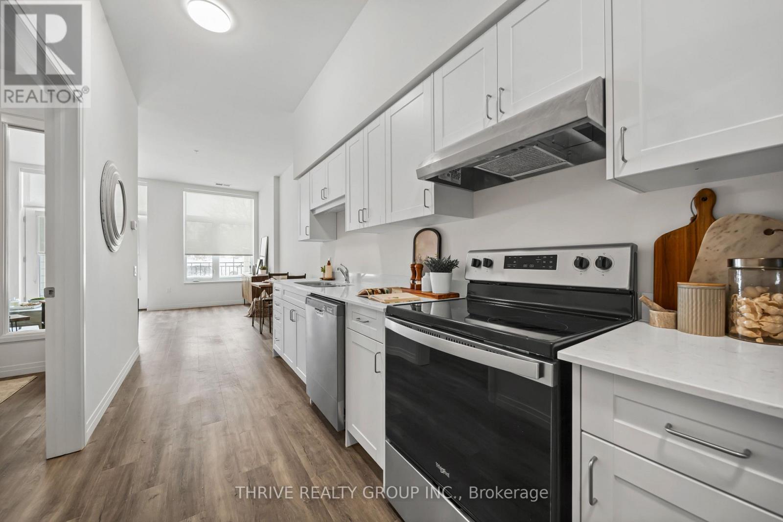 A modern kitchen with a stove top oven and white cabinets.