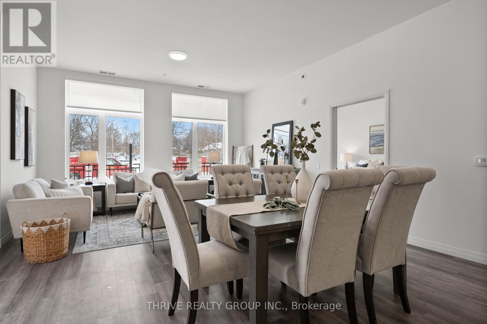 A dining room with a table set for six and a view of a snowy landscape outside the window.