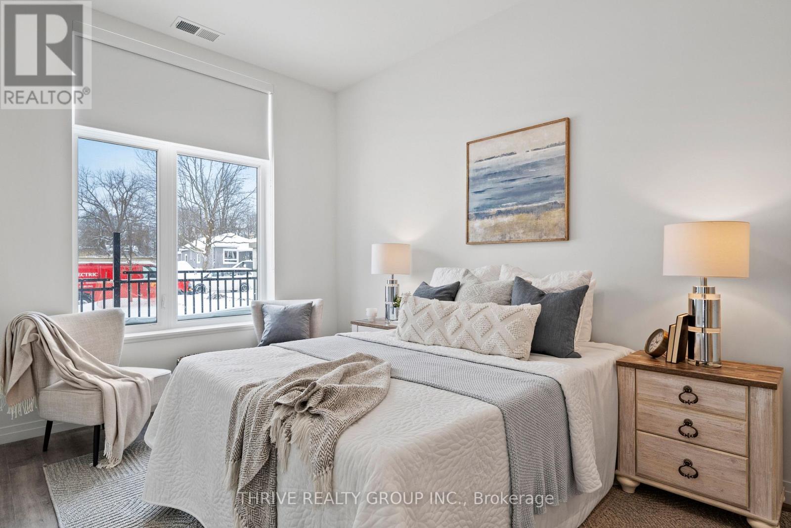 A bedroom with a large bed and a painting on the wall.