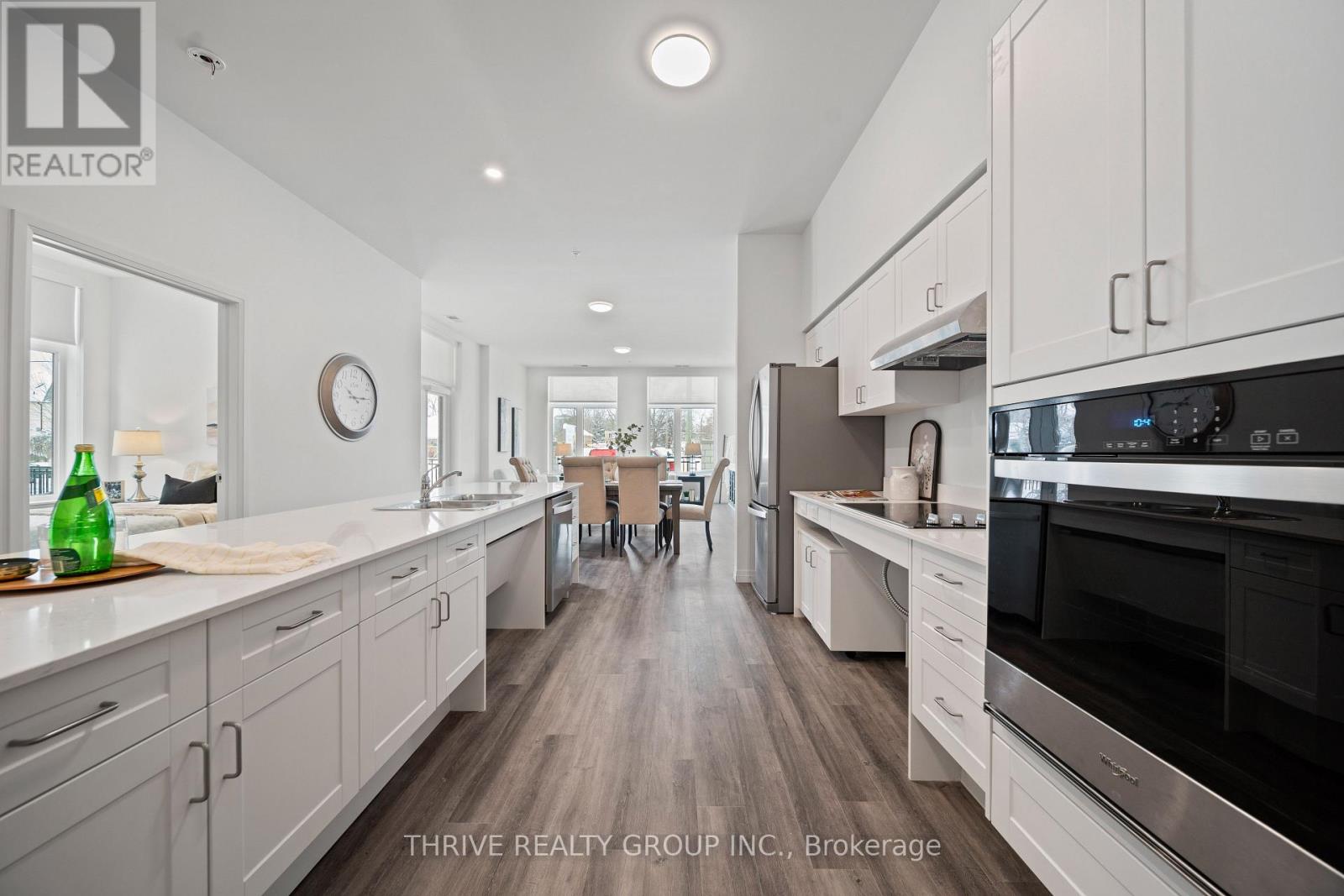 A modern kitchen with white cabinets and stainless steel appliances.