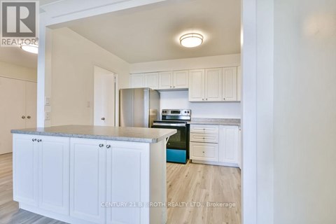A kitchen with white cabinets and a blue island.