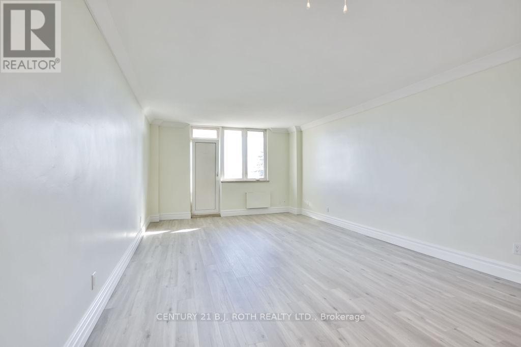 A spacious room with wooden floors and white walls.