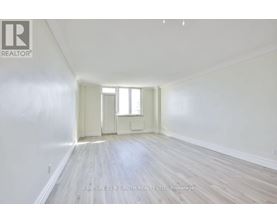 A spacious room with wooden floors and white walls.