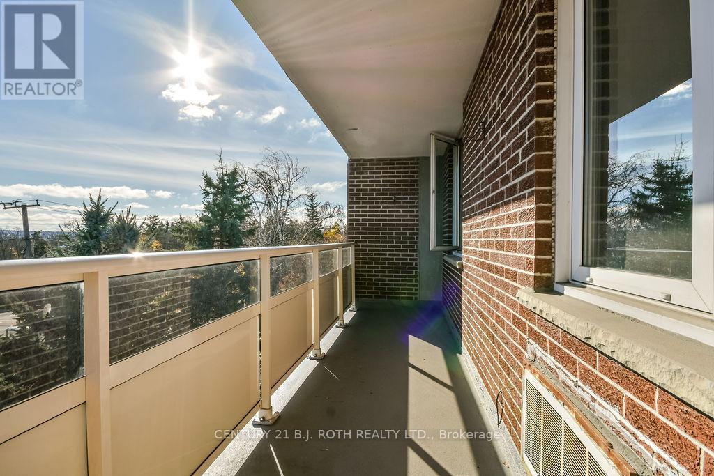 A balcony with a view of trees and a clear sky.