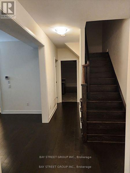 A hallway with a staircase and a door.