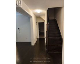 A hallway with a staircase and a door.