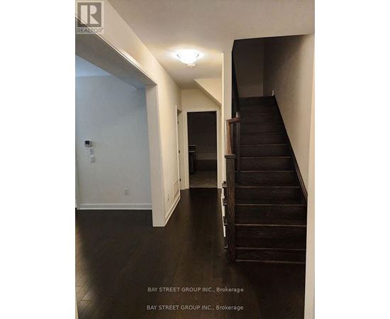 A hallway with a staircase and a door.