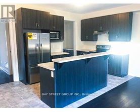 A kitchen with a refrigerator, microwave, and oven.