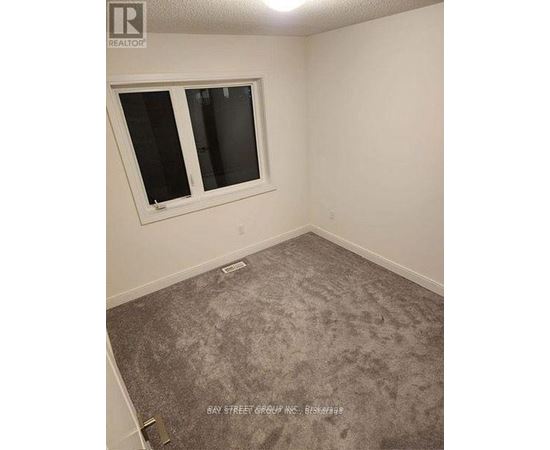 A room with a carpeted floor and a window.