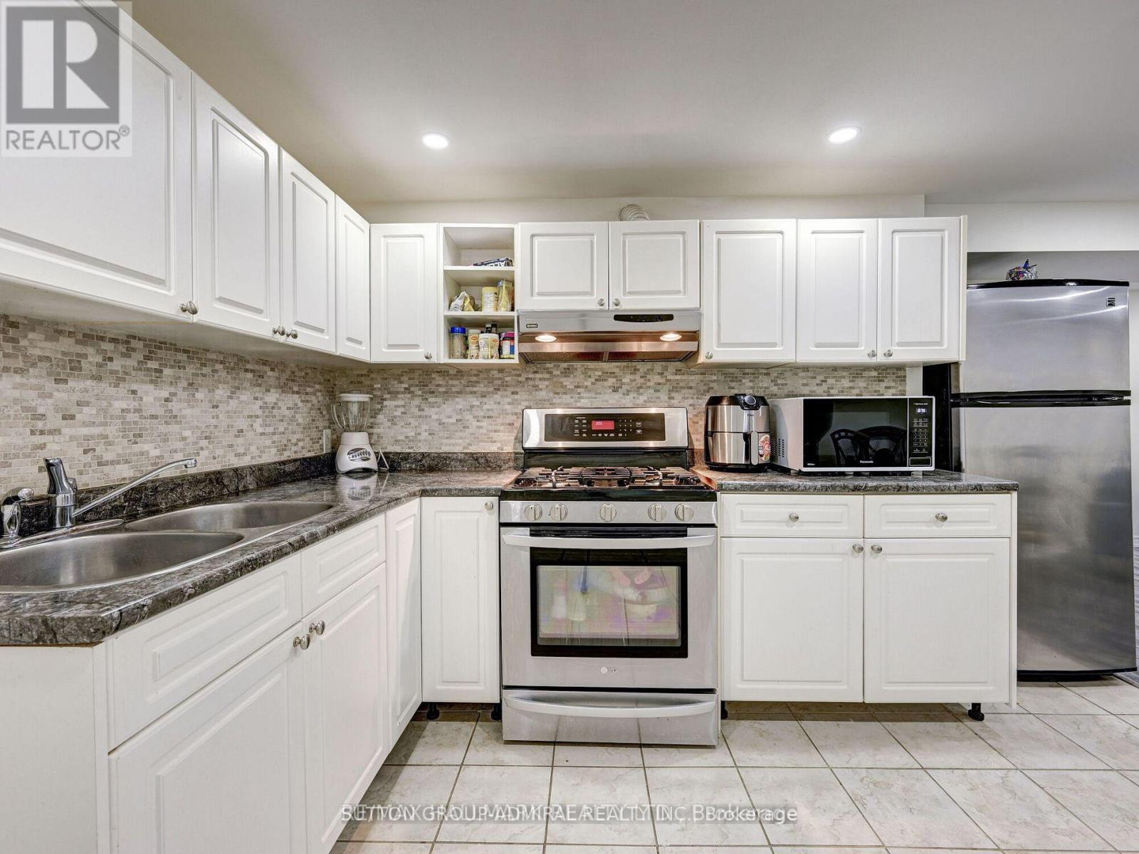 A kitchen with white cabinets and a granite countertop.