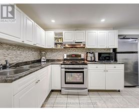 A kitchen with white cabinets and a granite countertop.