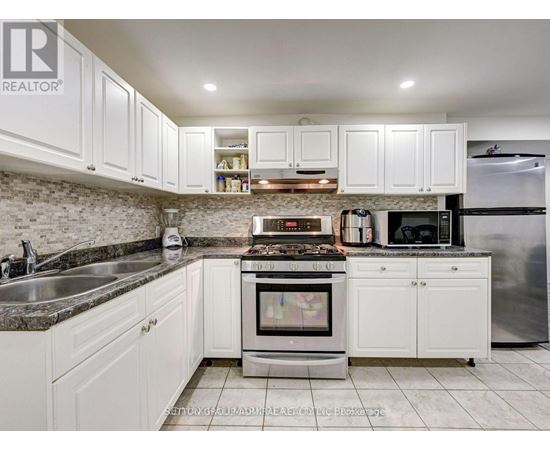 A kitchen with white cabinets and a granite countertop.