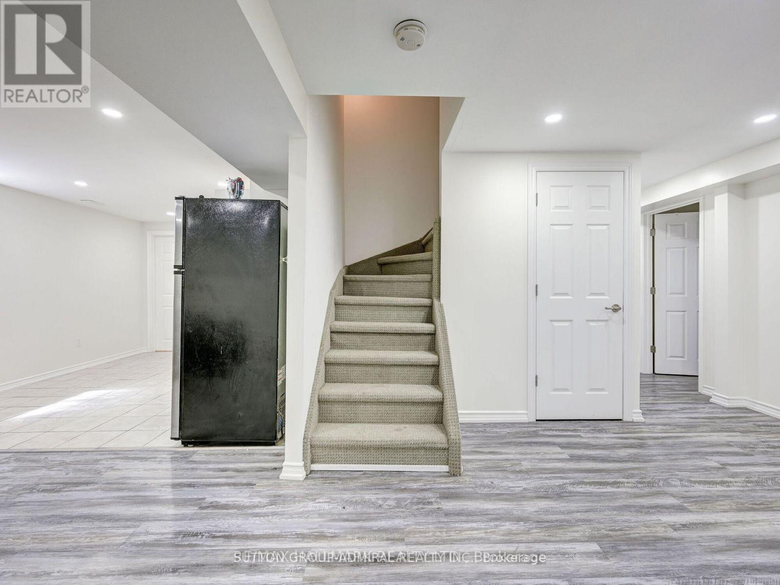 A staircase with a metal railing leads up to a white door.