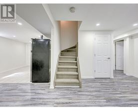 A staircase with a metal railing leads up to a white door.