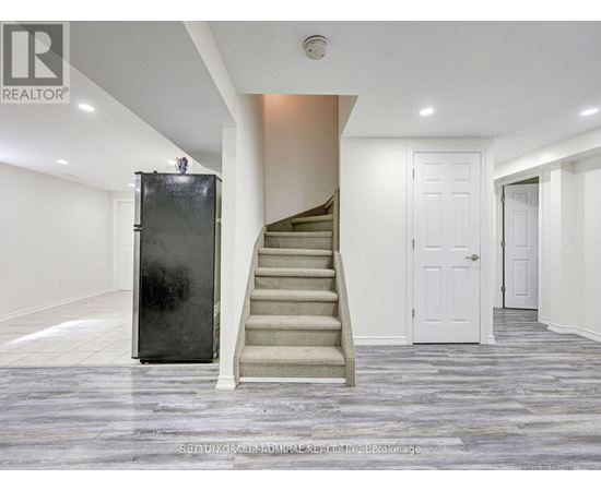 A staircase with a metal railing leads up to a white door.