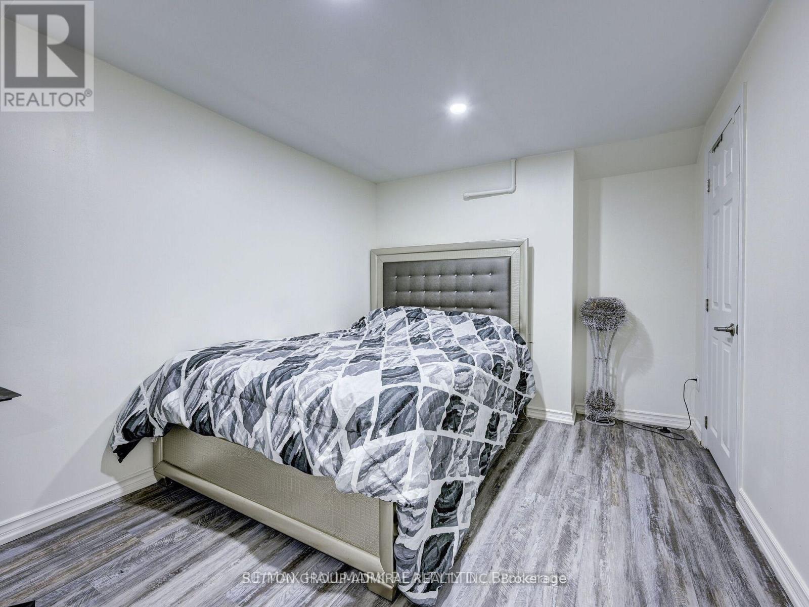 A bedroom with a bed, a lamp, and a window.