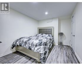 A bedroom with a bed, a lamp, and a window.