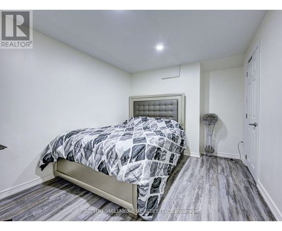 A bedroom with a bed, a lamp, and a window.