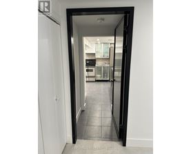 A black doorway opens to a kitchen.