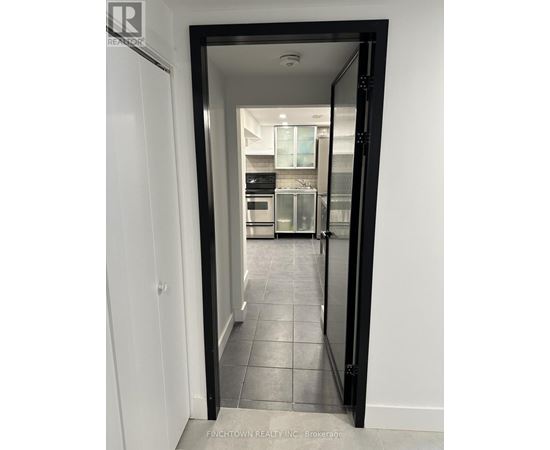 A black doorway opens to a kitchen.