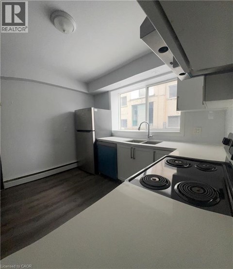 A kitchen with a stove top oven and a refrigerator.